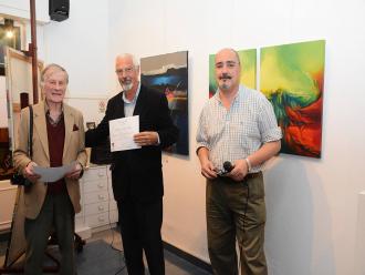 Miguel Francisco Facioli recebe o Certificado de participação na mostra.